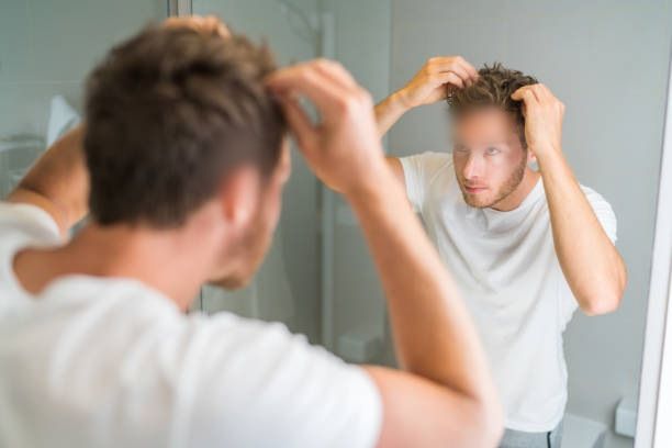 Homme se coiffant devant un miroir