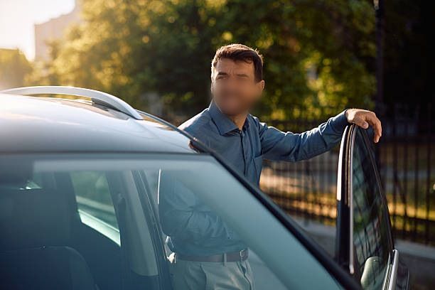 Homme appuyé contre une voiture